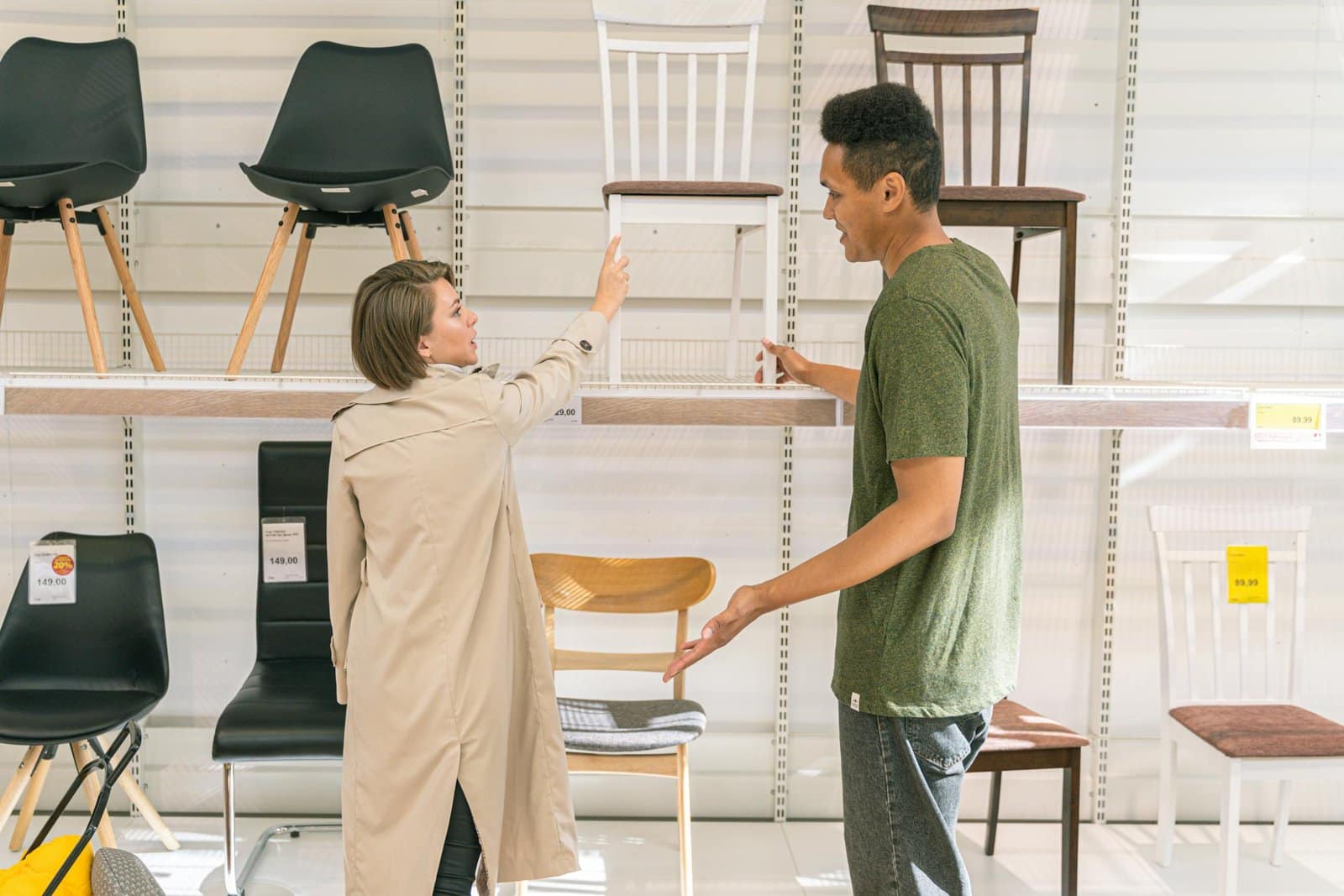 A couple explores chair options together in a modern furniture store during the day.